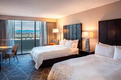 a hotel room with two beds and a balcony at Renaissance Denver Hotel & Conference Center in Denver