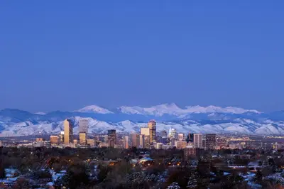 a city skyline with snow covered mountains in the background at Renaissance Denver Hotel & Conference Center in Denver