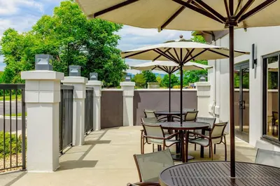 an outdoor patio with tables and chairs and umbrellas at SpringHill Suites Denver North / Westminster in Westminster