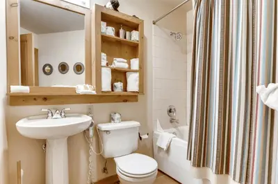 a bathroom with a toilet and a sink and a tub at River Run Village 1 Bedroom Condo in Keystone