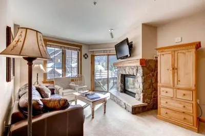 a living room with a couch and a fireplace at River Run Village 2 Bedroom Condo - 100 Yards To Slopes, Pool, Hot Tub Access in Keystone