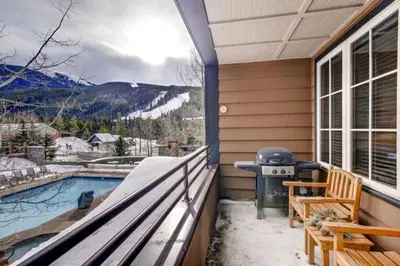 a screened in porch with a grill and a pool at River Run Village 2 Bedroom Condo - 100 Yards To Slopes, Pool, Hot Tub Access in Keystone