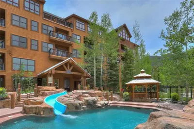 a pool in front of a building with a resort at 3 Bedroom Condo In River Run With Shared Pool, Hot Tubs, 100 Yards To Gondola in Keystone