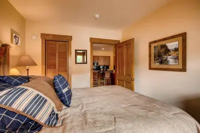 a bedroom with a bed with blue and white pillows at 3 Bedroom Condo In River Run With Shared Pool, Hot Tubs, 100 Yards To Gondola in Keystone