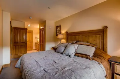 a bedroom with a large bed with a wooden headboard at 3 Bedroom Condo In River Run With Shared Pool, Hot Tubs, 100 Yards To Gondola in Keystone