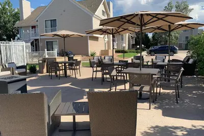 an outdoor patio with tables and chairs and umbrellas at Residence Inn Denver Tech Center in Greenwood Village
