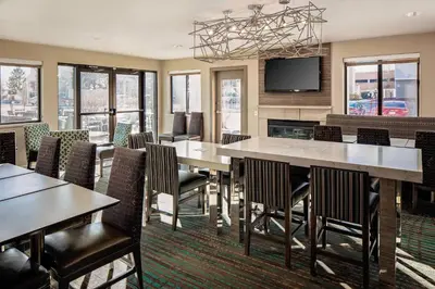 a dining room with tables and chairs and a flat screen tv at Residence Inn Denver Tech Center in Greenwood Village