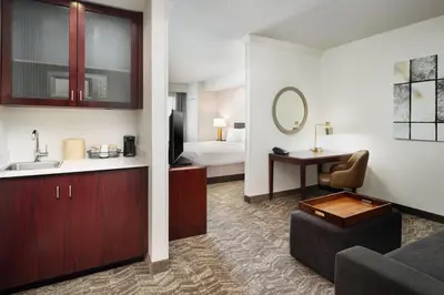 a hotel room with a sink and a bed at SpringHill Suites Boulder Longmont in Longmont