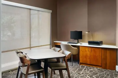 a room with a table and chairs and a desk at SpringHill Suites Boulder Longmont in Longmont