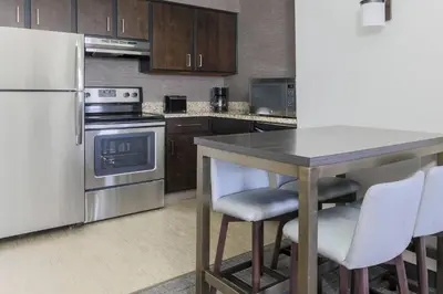 a kitchen with a white refrigerator and a table with chairs at Residence Inn by Marriott Denver Golden/Red Rocks in Golden
