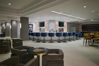 a restaurant with a bar with blue chairs and tables at Denver Airport Marriott at Gateway Park in Aurora