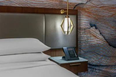 a bedroom with a bed and a phone on a table at Denver Airport Marriott at Gateway Park in Aurora
