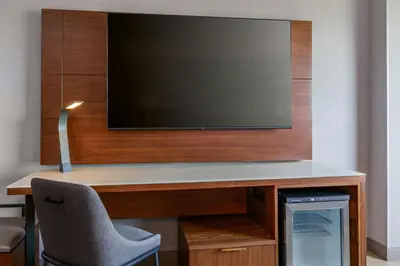 a room with a desk with a tv and a chair at Denver Airport Marriott at Gateway Park in Aurora
