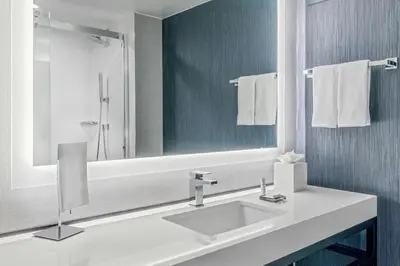 a white bathroom with a sink and a mirror at Denver Airport Marriott at Gateway Park in Aurora