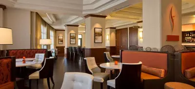 a restaurant with tables and chairs and a bar at Denver Airport Marriott at Gateway Park in Aurora