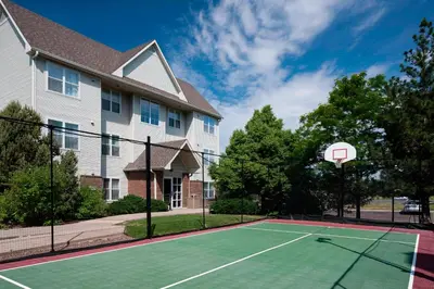 a tennis court in front of a house with a basketball hoop at Residence Inn Denver Highlands Ranch in Highlands Ranch