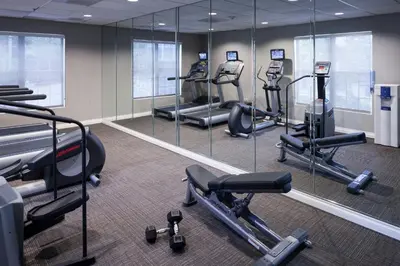 a gym with several tread machines and mirrors at Residence Inn Denver Highlands Ranch in Highlands Ranch
