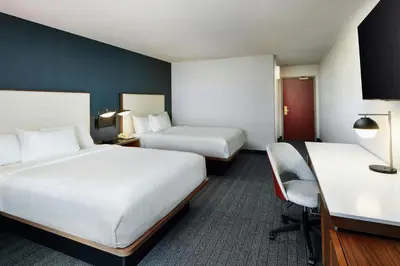 a hotel room with two beds and a desk at Courtyard Boulder Longmont in Longmont