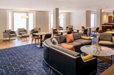 a living room with couches and tables and chairs at Courtyard by Marriott Denver Southwest Lakewood in Lakewood