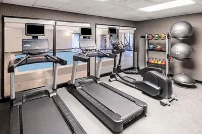 a gym with three treadmills and a pool at Courtyard by Marriott Denver Southwest Lakewood in Lakewood