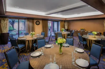 a dining room with tables and chairs and a room with windows at Courtyard by Marriott Denver Southwest Lakewood in Lakewood