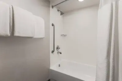 a white bathroom with a shower and a sink at Courtyard by Marriott Boulder Broomfield in Louisville