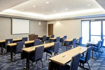 a conference room with tables and chairs and a whiteboard at Courtyard by Marriott Boulder Broomfield in Louisville