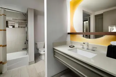 a bathroom with a sink and a toilet and a mirror at Renaissance Boulder Flatiron Hotel in Broomfield