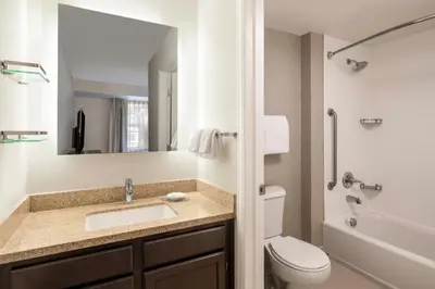 a bathroom with a sink and a toilet and a mirror at Residence Inn Denver Southwest/Lakewood in Lakewood