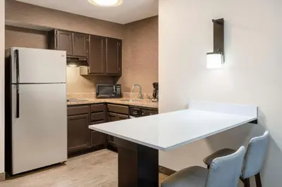 a kitchen with a refrigerator and a table and chairs at Residence Inn Denver Southwest/Lakewood in Lakewood