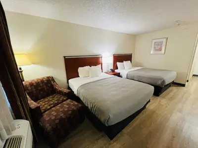 a hotel room with two beds and a chair at Quality Inn & Suites Golden - Denver West in Lakewood