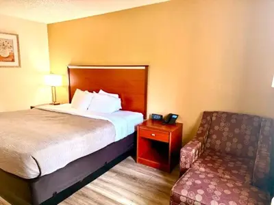 a hotel room with a bed and a chair at Quality Inn & Suites Golden - Denver West in Lakewood