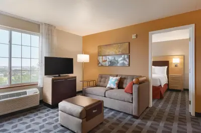 a living room with a couch and a tv and a bed at TownePlace Suites by Marriott Boulder Broomfield/Interlocken in Broomfield