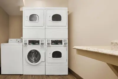 a laundry room with three washing machines and a counter at TownePlace Suites by Marriott Boulder Broomfield/Interlocken in Broomfield