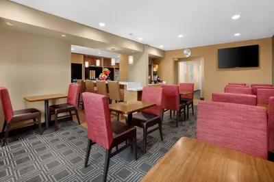 a dining room with red chairs and tables at TownePlace Suites by Marriott Boulder Broomfield/Interlocken in Broomfield