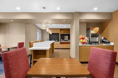 a kitchen and dining room with tables and chairs at TownePlace Suites by Marriott Boulder Broomfield/Interlocken in Broomfield