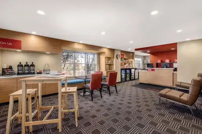 a lobby with a table and chairs and a bar at TownePlace Suites by Marriott Denver West Federal Center in Lakewood