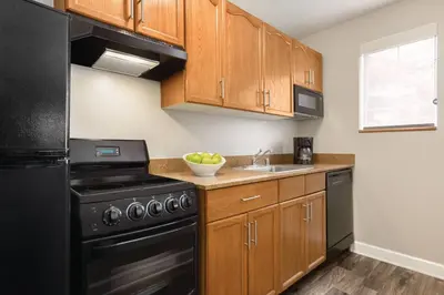 a kitchen with black appliances and wooden cabinets at TownePlace Suites by Marriott Denver West Federal Center in Lakewood