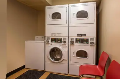 a laundry room with a washing machine and a red chair at TownePlace Suites by Marriott Denver West Federal Center in Lakewood