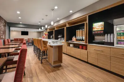 a restaurant with a bar and tables and chairs at TownePlace Suites by Marriott Denver West Federal Center in Lakewood