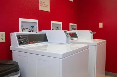 two washing machines in a room with a red wall at TownePlace Suites Denver Southwest/Littleton in Littleton