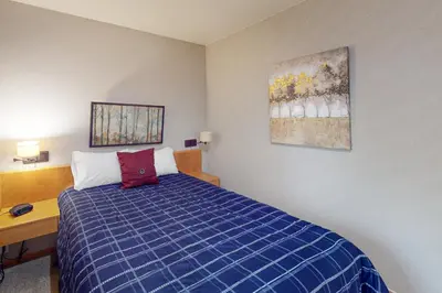 a bedroom with a blue bed and a wooden desk at River Bank Lodge 2924 in Keystone