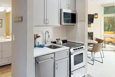 a white kitchen with a sink and a stove at River Bank Lodge 2924 in Keystone