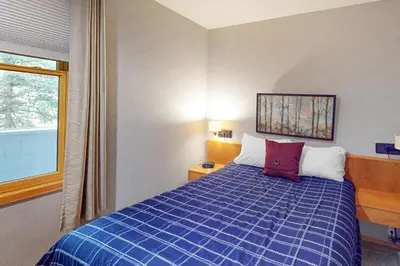 a bedroom with a blue bed with a red pillow at River Bank Lodge 2924 in Keystone