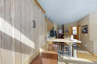 a kitchen with a table and stools in a room at River Bank Lodge 2919 in Keystone