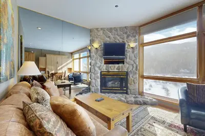 a living room with a couch and a fireplace at River Bank Lodge 2919 in Keystone