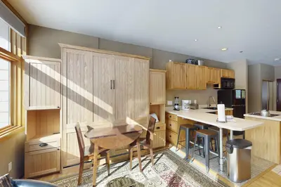 a kitchen with wooden cabinets and a table and chairs at River Bank Lodge 2919 in Keystone