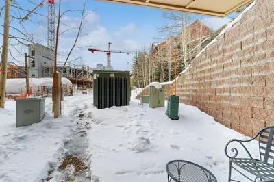 a snow covered sidewalk with two benches in front of a building at Red Hawk Lodge 2200 in Dillon