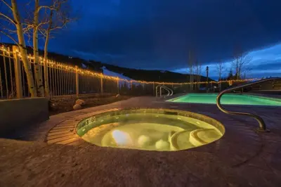 a hot tub in a patio with a pool at night at Red Hawk Lodge 2200 in Dillon