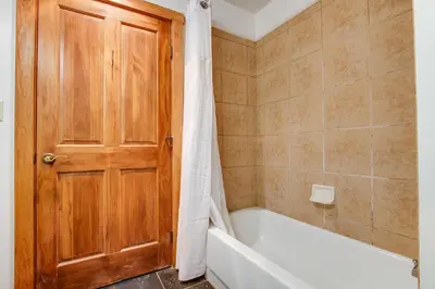 a bathroom with a wooden door and a bath tub at Red Hawk Lodge 2286 in Dillon